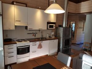 a kitchen with white cabinets and a stove top oven at Vutnusmaja air-conditioned holiday home at Iso-Syöte in Syöte