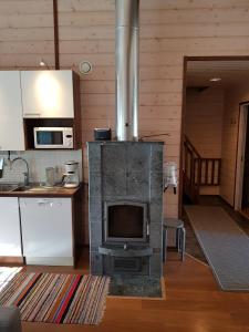una cocina con una antigua estufa en una habitación en Air-conditioned holiday home Vutnusmaja at Iso-Syöte, en Syöte