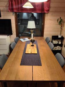 einem Holztisch mit einer Lampe darüber in der Unterkunft Air-conditioned holiday home Vutnusmaja at Iso-Syöte in Syöte