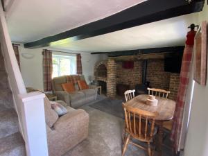 a living room with a couch and a table at Honeysuckle Cottage in Dorchester