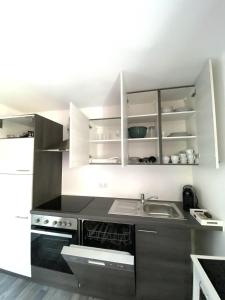 una cucina con armadi bianchi e lavandino di Apartment Mona´s Home a Sankt Pankraz