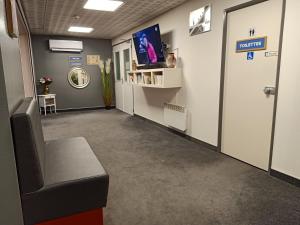 a waiting room with a chair and a tv at Astrotel Romorantin-Lanthenay Soirée étape in Romorantin