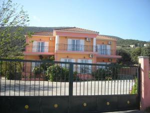 a pink house with a fence in front of it at Margarita Studios in Sami