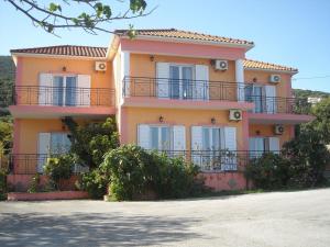 a large orange house with balconies on the side of it at Margarita Studios in Sami