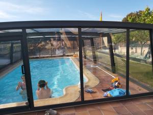 a group of children sitting around a swimming pool at El Lagar de La Navazuela in La Rasa