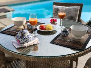 a table with food and drinks on a table with chairs at Samui Blu, villa with private pool in Choeng Mon Beach