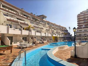 duży hotel z basenem przed budynkiem w obiekcie Rentaliday Flor de Cia w Playa de las Americas
