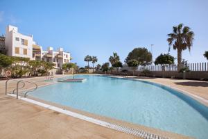 a large swimming pool in front of some buildings at Los Martínez Duplex in El Médano