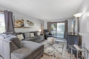 ein Wohnzimmer mit einem Sofa und einem Tisch in der Unterkunft Spacious Modern Condo - 1st Floor - One Block to the Beach in Myrtle Beach