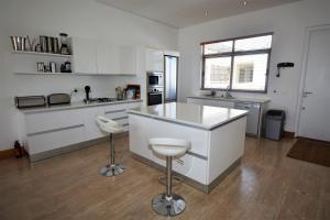 a kitchen with white cabinets and a white counter top at The Square 10 in Plettenberg Bay