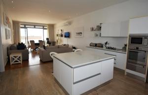 a kitchen and living room with a white counter top at The Square 10 in Plettenberg Bay