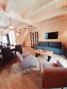 a living room with a blue couch and a table at Alpenchalets Nassfeld in Rattendorf