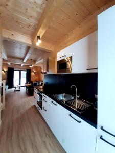 a kitchen with white cabinets and a black counter top at Alpenchalets Nassfeld in Rattendorf