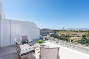 a balcony with a table and chairs and a view of a city at Apartamentos Benimar in Benijófar