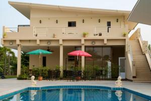 une maison avec deux parasols et une piscine dans l'établissement Relax Garden House, à Chiang Mai