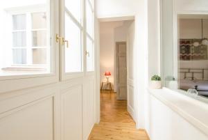 a hallway with white walls and a window at Wishlist Prague Residences - Charles Bridge Karlova in Prague