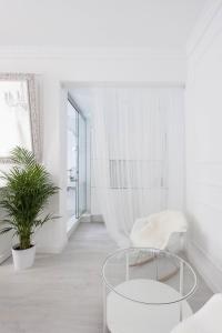 
a white room with a white table and a white rug at Urban Suite Santander in Santander
