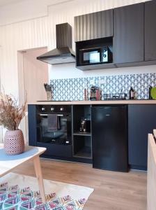 a kitchen with a black refrigerator and a stove at LITTLE BAHIA in Saint Malo