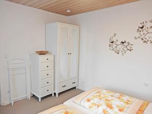 ミッテンヴァルトにあるHaus Maria Elisabethの白いキャビネットとベッド付きのベッドルーム1室