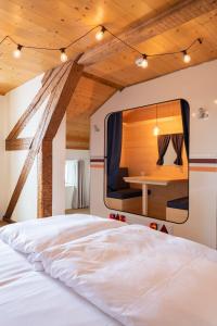 1 dormitorio con 1 cama y TV en la pared en Peanut Mountain Lodge & Le Communal en Val dʼIlliez