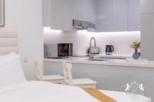 cocina blanca con cama y lavamanos en Westminster Burj Al Nujoom en Dubái