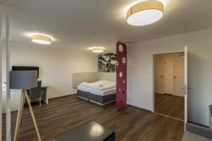 a room with a bedroom with a bed and a table at Hotel Garni VŠB in Ostrava