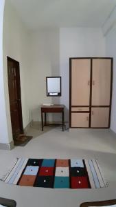 Victoria Guest House في بهاوالبور: غرفة بها تلفزيون وطاولة وسجادة
