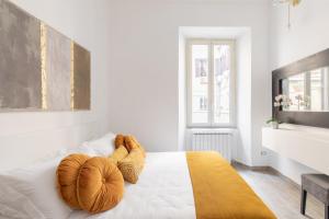 a white bedroom with a bed with two large objects on it at iFlat Monti Elegant Apartment with Terrace in Rome