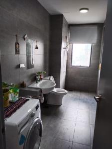 a bathroom with a toilet and a sink and a washing machine at Usj One Residence @ Homestay in Subang Jaya