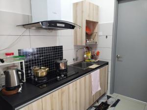 a small kitchen with a stove and a sink at Usj One Residence @ Homestay in Subang Jaya