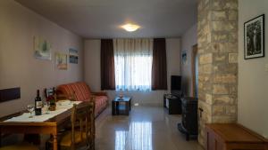 a living room with a table and a couch and a living room with a stone at Apartment Kremžar Lokve in Lokve