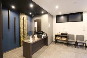 a waiting room with two chairs and a table and a counter at M's Hotel Sanjo Wakoku in Kyoto