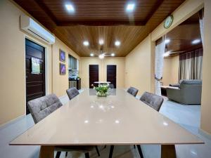 a dining room with a large white table and chairs at BUNGALOW D'CENANG- Private Pool in Pantai Cenang