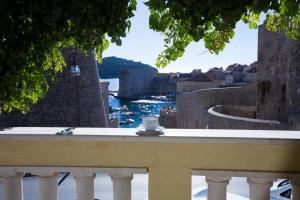 a cup of coffee sitting on a balcony overlooking the water at Apartment Nera in Dubrovnik