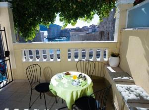 Apartment Nera في دوبروفنيك: طاولة على شرفة مع طاولة وكراسي