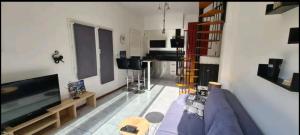 uma sala de estar com um sofá azul e uma televisão em Proche mer appartement avec jardin,place parking. em Elne