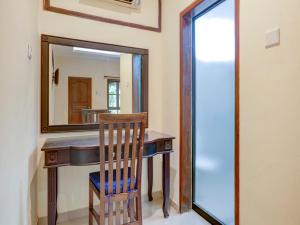 a dressing table with a chair and a mirror at OYO 1762 Hotel Astiti Graha Tanah Lot in Tanah Lot