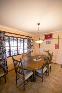 a dining room with a wooden table and chairs at Sneezewood in Dullstroom