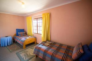 a bedroom with two beds and a window at Sneezewood in Dullstroom
