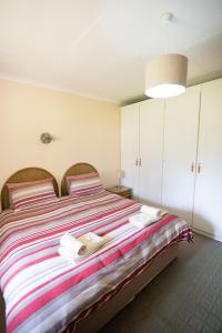 a bedroom with a large bed with towels on it at Sneezewood in Dullstroom