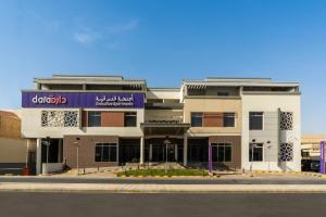 un edificio con un letrero púrpura en la parte delantera. en Dara Al Rayan en Riad