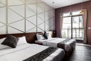 een hotelkamer met 2 bedden en een raam bij Toutsu Asami Guest House in Donggang