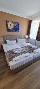 a bedroom with two large beds and a painting on the wall at Pension am Stern in Leipzig