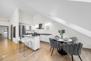 a kitchen and dining room with a table and chairs at Kaunas Old Town apartment with underground parking in Kaunas +11 photos