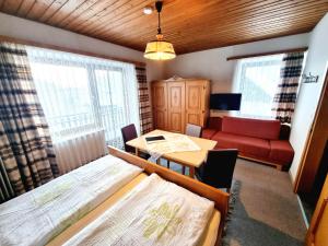 a room with two beds and a table and a couch at Guesthouse Schoba Typ B in Oberdöbernitzen