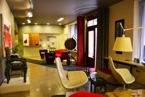 Hotel Colombia في ترييستي: غرفة معيشة مع مجموعة من الكراسي والطاولات