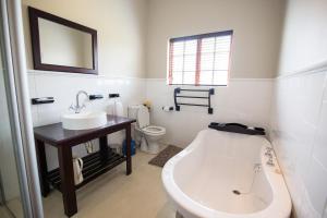 a bathroom with a tub and a sink and a toilet at Sorgenvrei in Dullstroom