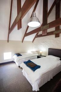 two beds in a room with wooden beams at Sorgenvrei in Dullstroom