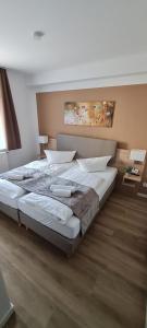 1 dormitorio con 1 cama grande con sábanas blancas en Pension am Stern, en Leipzig