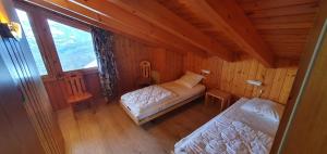 a bedroom with two beds in a wooden cabin at Mont Bijou MOUNTAIN & QUIET chalet 10 pers by Alpvision Résidences in Veysonnaz